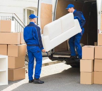 Two Movers in blue uniform Loading white color sofa in Truck