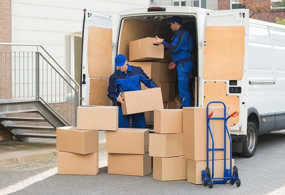 Two Movers in blue Uniform Unloading boxes from Truck